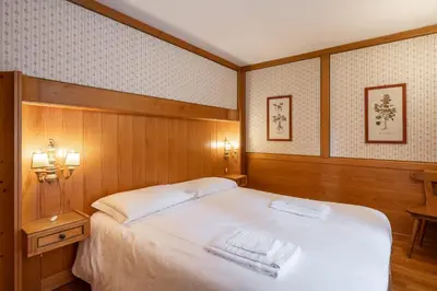 a bedroom with a large bed with two towels on it at Cozy 3 bedroom with access to garden in Cortina dʼAmpezzo