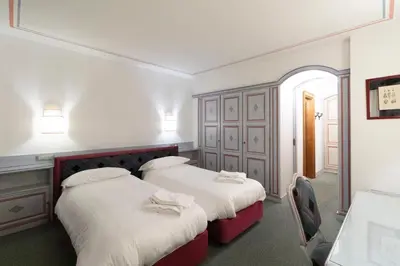 two beds in a room with white and red at Chalet Stadio in Cortina dʼAmpezzo