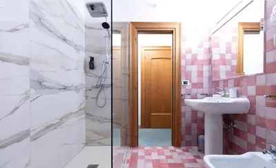 a bathroom with pink tiles and a sink and a shower at Chalet Stadio in Cortina dʼAmpezzo