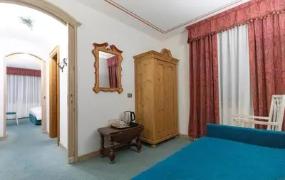 a bedroom with a blue bed and a mirror at Chalet Stadio in Cortina dʼAmpezzo