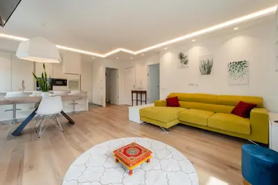 a living room with a yellow couch and a table at Villa Silvio in Castello di Fiemme