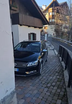 a black car parked next to a building at Comodo e luminoso, splendida vista su Cortina in Cortina dʼAmpezzo