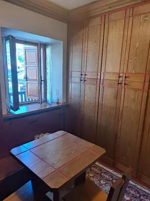 a dining room with a wooden table and a window at Comodo e luminoso, splendida vista su Cortina in Cortina dʼAmpezzo