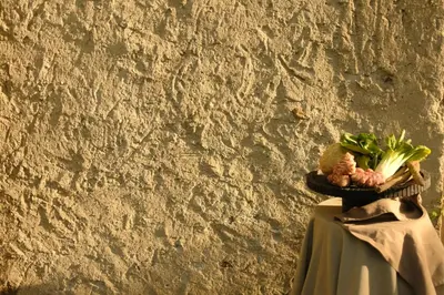 a plate of vegetables on a table next to a wall at Hotel Mühlbacherhof in Lagundo
