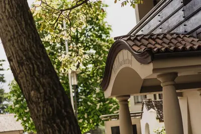 a corner of a house with a tree next to it at Hotel Mühlbacherhof in Lagundo