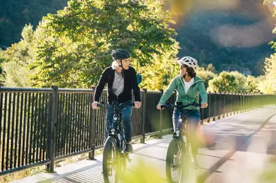two people riding their bikes on a bridge at Hotel Mühlbacherhof in Lagundo