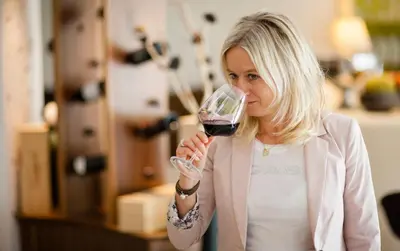 a woman drinking a glass of red wine at Hotel Mühlbacherhof in Lagundo