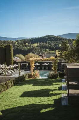 a view of a yard with chairs and a pool at Tirolensis - Luxury All Inclusive in Tesimo