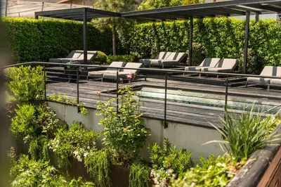 a swimming pool with lounge chairs and a swimming pool at Tirolensis - Luxury All Inclusive in Tesimo