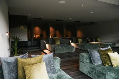 a lobby with green couches and pillows at Tirolensis - Luxury All Inclusive in Tesimo