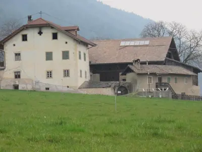 a large building in a field with a green field at Residence Adler in Tesimo