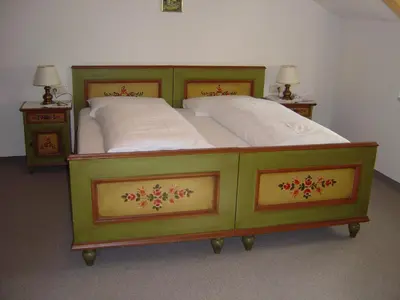 a green bed with white sheets and two night stands at Residence Adler in Tesimo