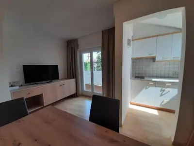 a living room with a dining table and a kitchen at Residence Adler in Tesimo