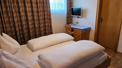 a hotel room with two beds and a television at Pension Pepi - Apartments I Bed - Breakfast in Perca