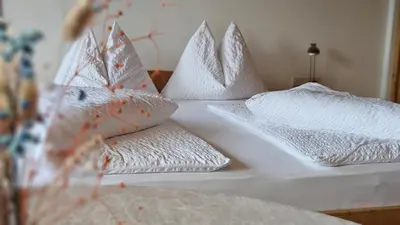 a white bed with pillows on it at Pension Pepi - Apartments I Bed - Breakfast in Perca