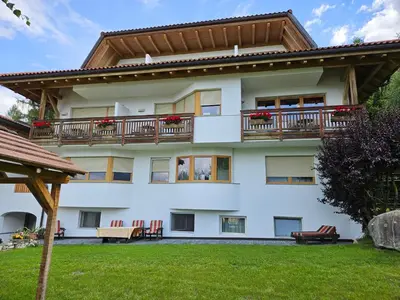 an apartment building with balconies and a yard at Pension Pepi - Apartments I Bed - Breakfast in Perca