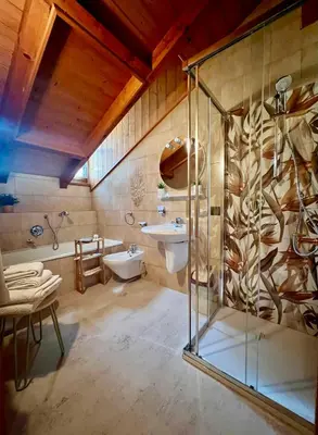 a bathroom with a glass shower and a sink at Stanza Roma in Tesero