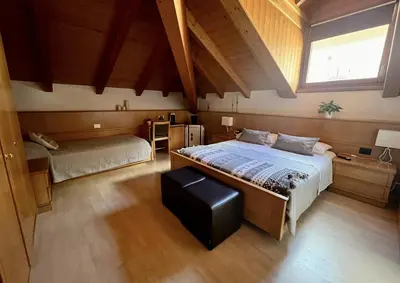 a bedroom with two beds and a window at Stanza Roma in Tesero