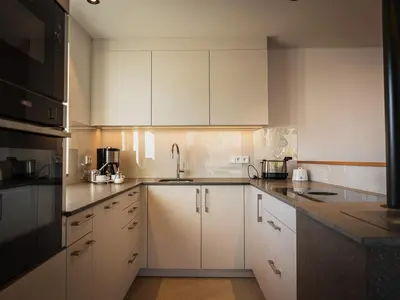a kitchen with white cabinets and a sink at Gruberhof Lana - NEW! in Lana