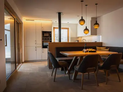 a kitchen and dining room with a wooden table and chairs at Gruberhof Lana - NEW! in Lana