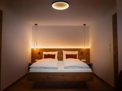 a bedroom with a bed with a light above it at Gruberhof Lana - NEW! in Lana