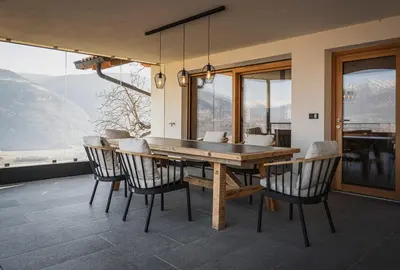 a dining room with a wooden table and chairs at Gruberhof Lana - NEW! in Lana