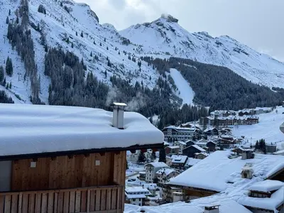 a town covered in snow with a mountain in the background at Ciasa Enrico in Arabba