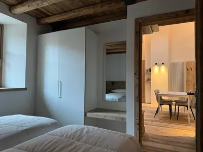 a bedroom with a bed and a desk in a room at Alpen Chic in Cavalese