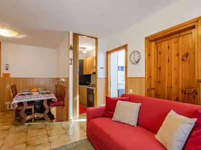 a living room with a red couch and a table at Apartment Condominio Val di Fassa-3 by Interhome in Alba di Canazei