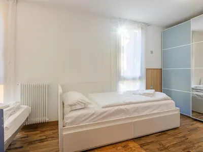 a bedroom with a white bed and a mirror at Apartment Condominio Val di Fassa-3 by Interhome in Alba di Canazei