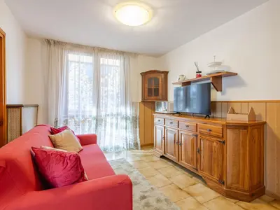 a living room with a red couch and a tv at Apartment Condominio Val di Fassa-3 by Interhome in Alba di Canazei