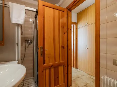 a bathroom with a sink and a shower and a door at Apartment Condominio Val di Fassa-3 by Interhome in Alba di Canazei