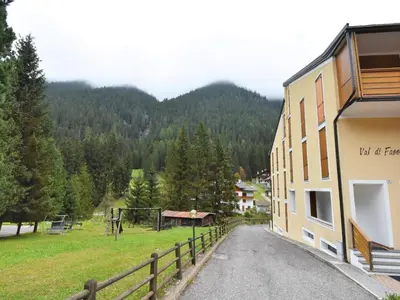 a building with a fence on the side of a road at Apartment Condominio Val di Fassa-3 by Interhome in Alba di Canazei