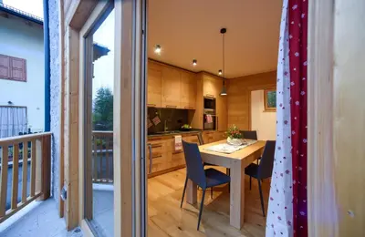 a kitchen and dining room with a table and chairs at Apartments Alla Caminada in Alleghe