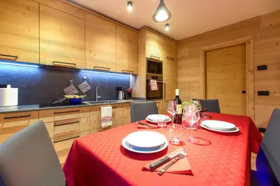 a dining room with a table with a red table cloth at Apartments Alla Caminada in Alleghe