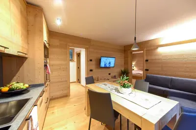 a kitchen and dining room with a table and chairs at Apartments Alla Caminada in Alleghe