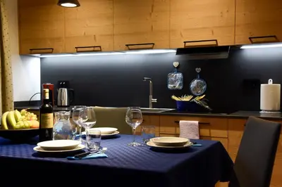 a table with a blue table cloth and wine glasses at Apartments Alla Caminada in Alleghe