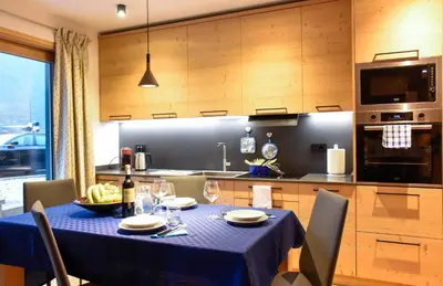 a dining room table with a blue table cloth on it in a kitchen at Apartments Alla Caminada in Alleghe