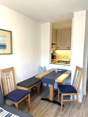 a dining room with a table and chairs and a kitchen at Apartements Mitterstill in Fiè