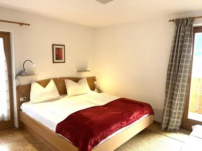 a bedroom with a bed with a red blanket at Apartements Mitterstill in Fiè