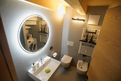 a bathroom with a mirror and a sink and a toilet at A93A Apartment Alicia in Carano