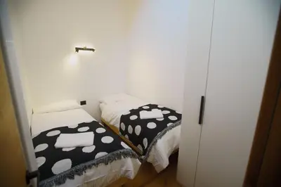 a room with two twin beds with black and white covers at A93A Apartment Alicia in Carano