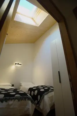 a bedroom with two beds and a skylight at A93A Apartment Alicia in Carano