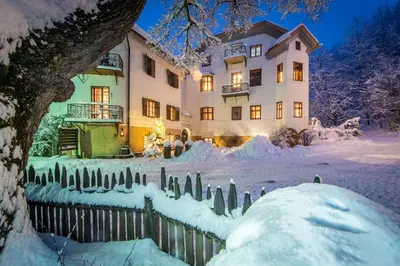 a house with a fence covered in snow at Apartments Ansitz Wildberg in San Lorenzo di Sebato