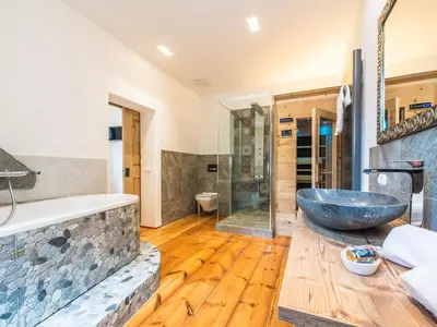 a bathroom with a large tub and a large stone sink at Apartments Ansitz Wildberg in San Lorenzo di Sebato