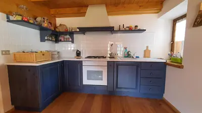 a kitchen with blue cabinets and a sink at Dolomites Holiday Home in Rivamonte