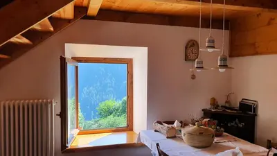 a room with a large window and a table at Dolomites Holiday Home in Rivamonte