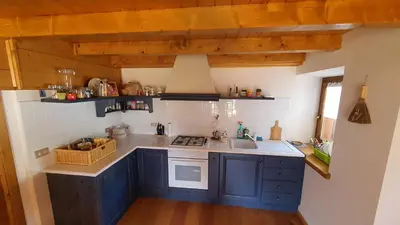 a kitchen with blue cabinets and a sink at Dolomites Holiday Home in Rivamonte
