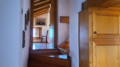 a hallway of a house with a wooden door at Dolomites Holiday Home in Rivamonte
