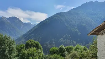 a view of a mountain range with trees and a house at Dolomites Holiday Home in Rivamonte